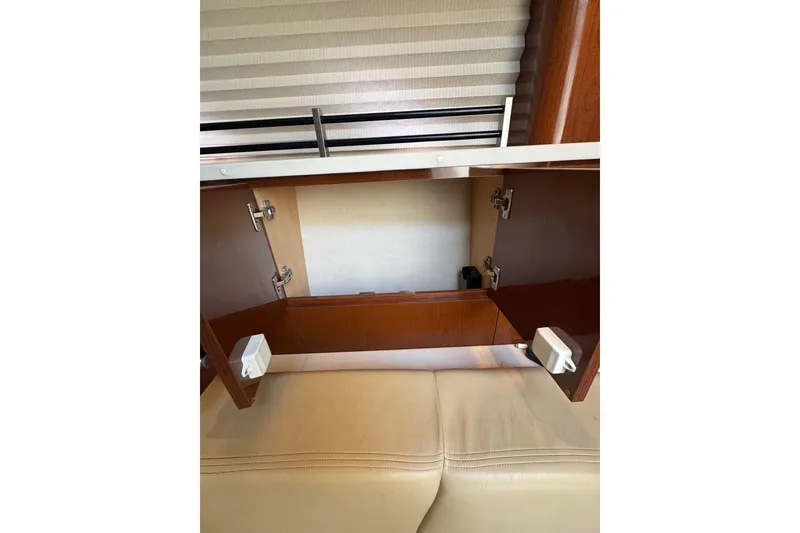 Slide: The Image of Open wooden cabinet inside 2010 Searay 330 Sundancer yacht, showcasing interior storage space. - 39