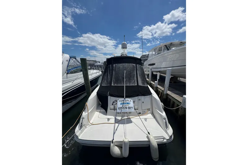 Slide: The Image of 2010 Searay 330 Sundancer boat docked, for sale sign visible, under a clear blue sky. - 4