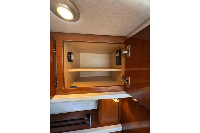 Slide: The Image of Open wooden cabinet in 2010 Searay 330 Sundancer boat interior, above beige seating. - 40
