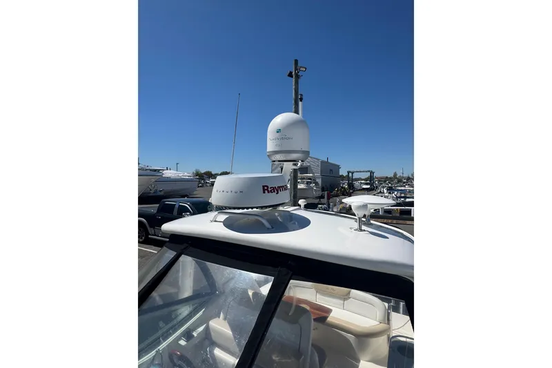 Slide: The Image of 2010 Searay 330 Sundancer yacht docked, showcasing sleek design and spacious deck. - 49