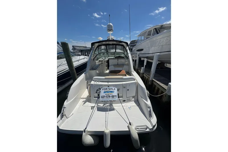Slide: The Image of 2010 Searay 330 Sundancer yacht docked, for sale sign visible, clear sky background. - 5