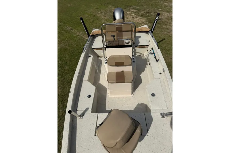 Slide: The Image of 2023 Xpress H20B Bay boat interior with seating and console, displayed on grass. - 11