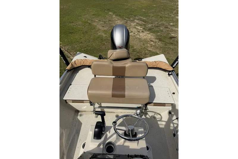 Slide: The Image of 2023 Xpress H20B Bay boat interior with tan seating and steering wheel. - 12