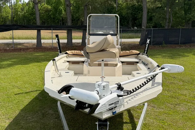 Slide: The Image of 2023 Xpress H20B Bay boat with Minn Kota trolling motor on grassy area. - 4