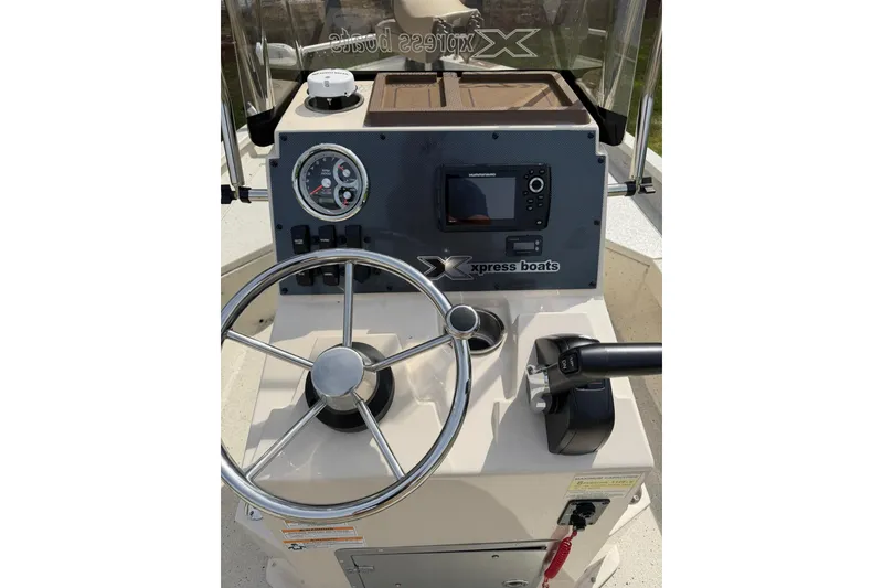 Slide: The Image of 2023 Xpress H20B Bay boat dashboard with steering wheel and control panel. - 8
