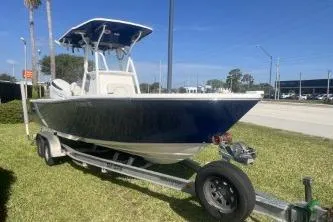 The Image of 2022 Sea Born LX24 Center Console boat on trailer, parked on grass. - 1