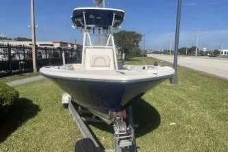 Slide: The Image of 2022 Sea Born LX24 Center Console boat on trailer, parked on grass. - 3