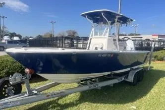 Slide: The Image of 2022 Sea Born LX24 Center Console boat on trailer, parked on grass. - 4