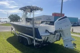 Slide: The Image of 2022 Sea Born LX24 Center Console boat on trailer, parked on grass. - 6
