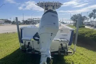 Slide: The Image of 2022 Sea Born LX24 Center Console boat with outboard motor, parked on grass. - 7