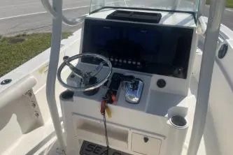 Slide: The Image of 2022 Sea Born LX24 Center Console boat dashboard with steering wheel and controls. - 9