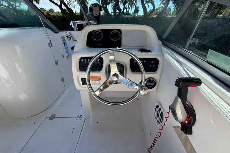 Slide: The Image of 2022 Robalo R207 Dual Console boat cockpit with steering wheel and controls. - 11