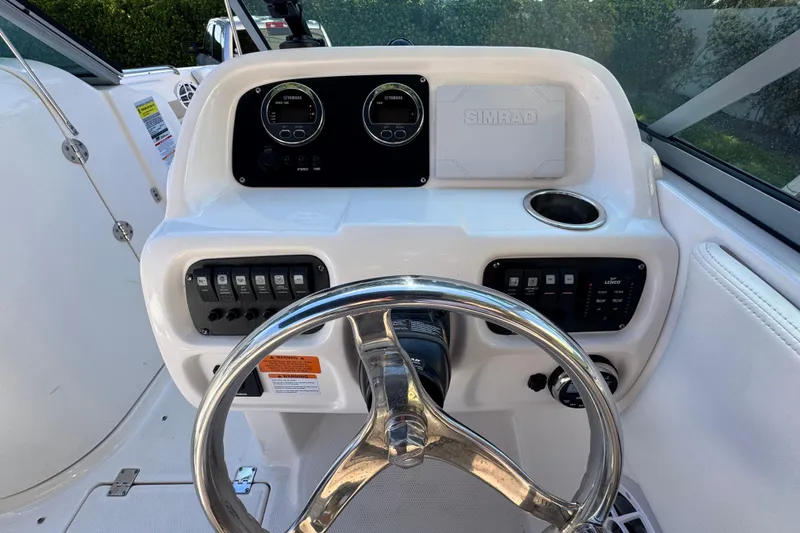 Slide: The Image of 2022 Robalo R207 Dual Console boat dashboard with steering wheel and control panel. - 14