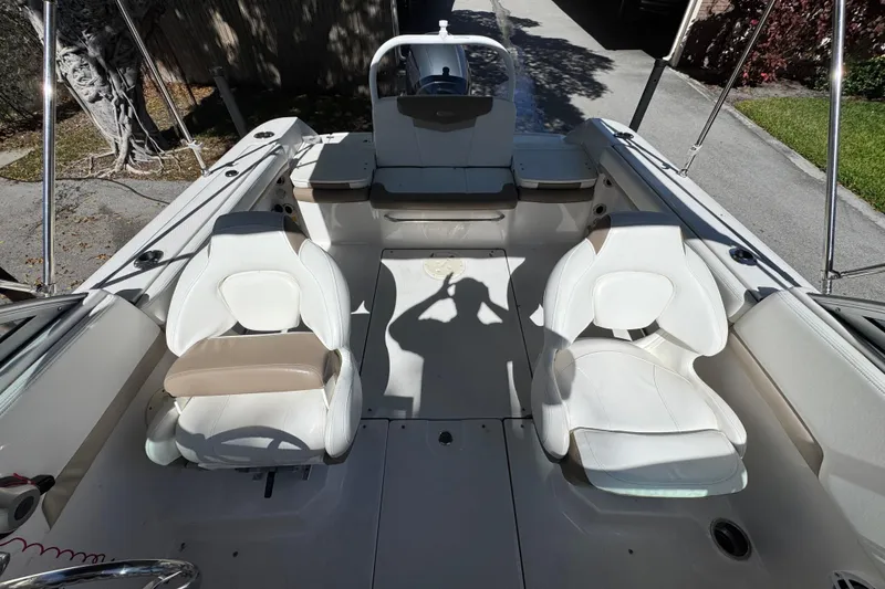 Slide: The Image of 2022 Robalo R207 Dual Console boat interior with white seating and steering wheel. - 7
