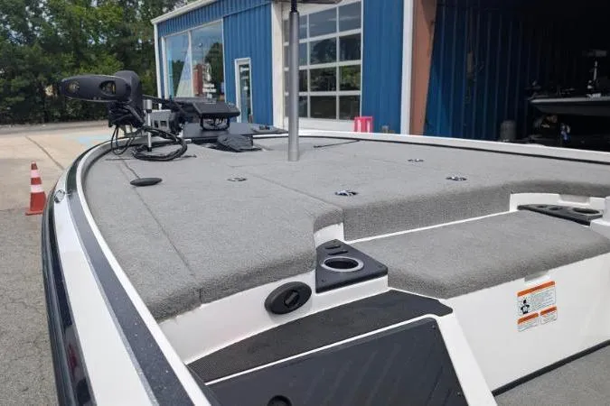 Slide: The Image of 2020 Nitro Z18 boat deck with fishing equipment, parked near a blue building. - 9