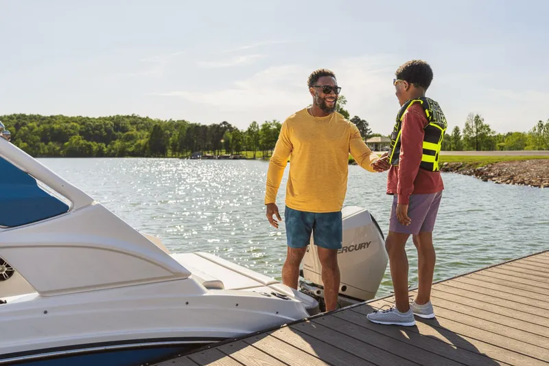 Slide: The Image of Father and son at dock with 2026 Sea Ray SDX 230 Outboard. - 22