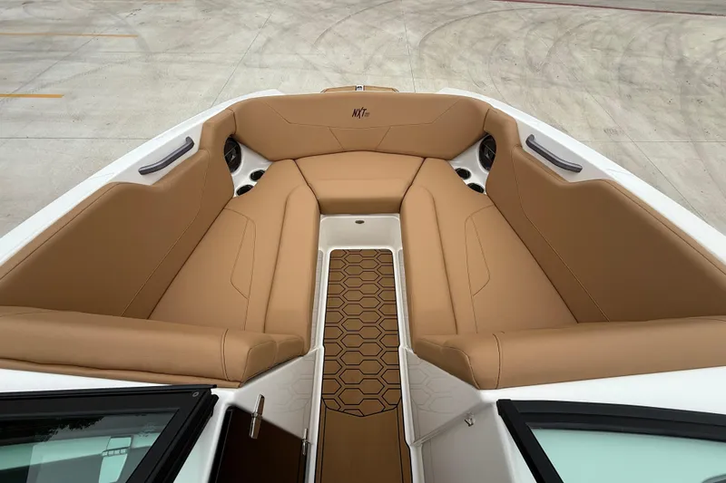 Slide: The Image of 2022 MasterCraft NXT22 boat interior with tan seating and hexagonal floor design. - 12