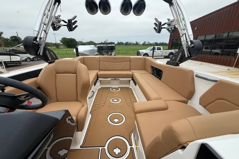 Slide: The Image of 2022 MasterCraft NXT22 boat interior with tan seating and modern audio system. - 13