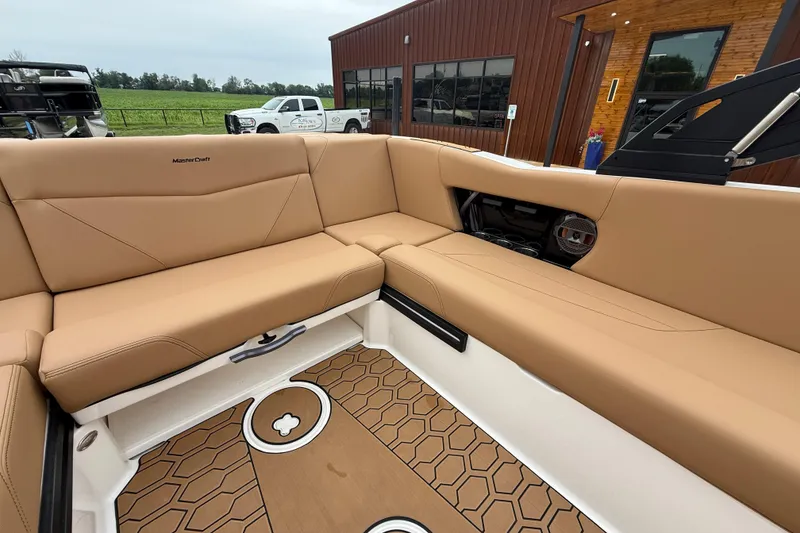 Slide: The Image of 2022 MasterCraft NXT22 boat interior with tan seating and stylish flooring. - 15