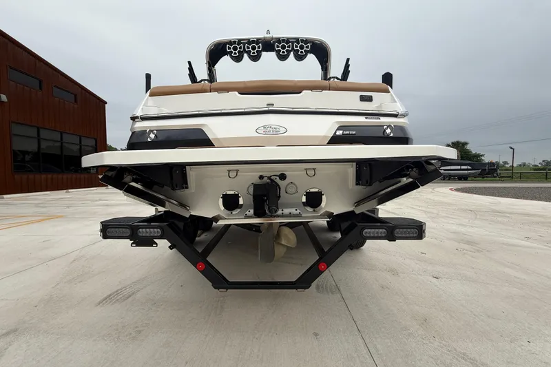 Slide: The Image of 2022 MasterCraft NXT22 boat rear view on concrete surface, showcasing design and features. - 5