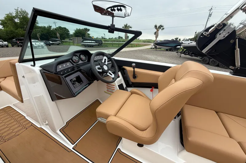 Slide: The Image of 2022 MasterCraft NXT22 boat interior with tan seats and modern dashboard. - 9