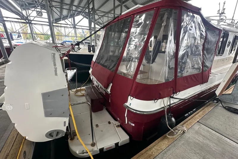 Slide: The Image of 2018 Ranger Tugs R-31 S docked with maroon canopy and swim platform. - 20