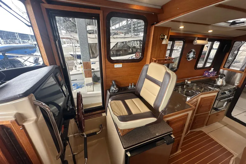 Slide: The Image of Interior of 2018 Ranger Tugs R-31 S, featuring helm seat and compact kitchen area. - 35