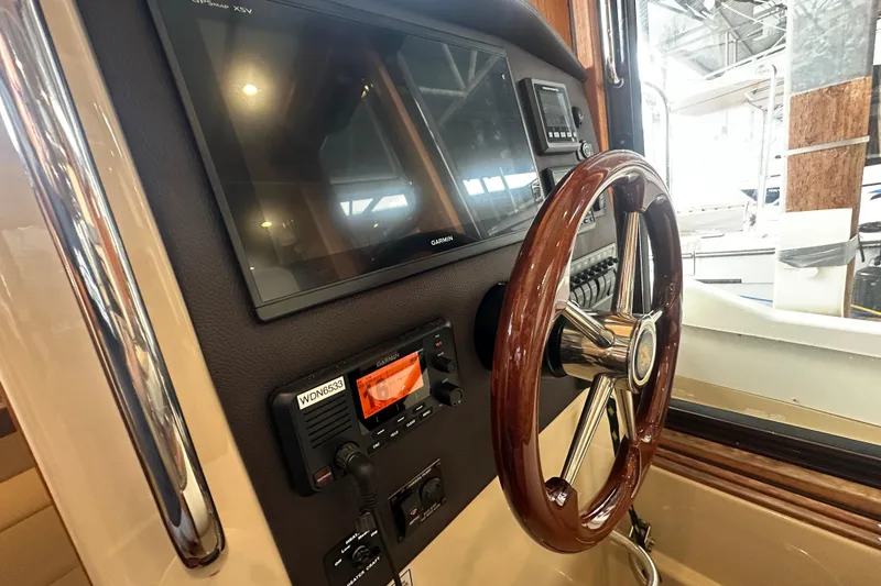 Slide: The Image of 2018 Ranger Tugs R-31 S helm with wooden steering wheel and Garmin navigation display. - 36