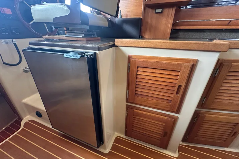 Slide: The Image of 2018 Ranger Tugs R-31 S interior with wooden cabinets and stainless steel fridge. - 42