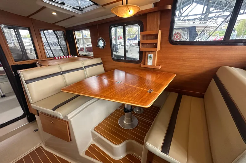 Slide: The Image of Interior of 2018 Ranger Tugs R-31 S with wood table and beige seating. - 43