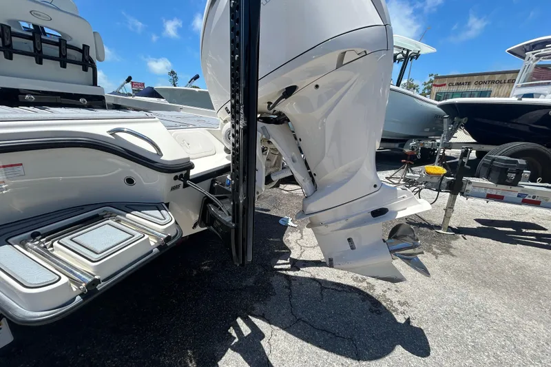 Slide: The Image of 2022 Pathfinder 2600 TRS boat with outboard motor and swim platform in a sunny marina. - 5