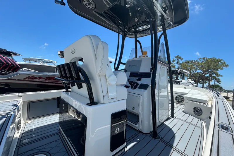 Slide: The Image of 2022 Pathfinder 2600 TRS boat interior with helm and seating, under clear blue sky. - 8