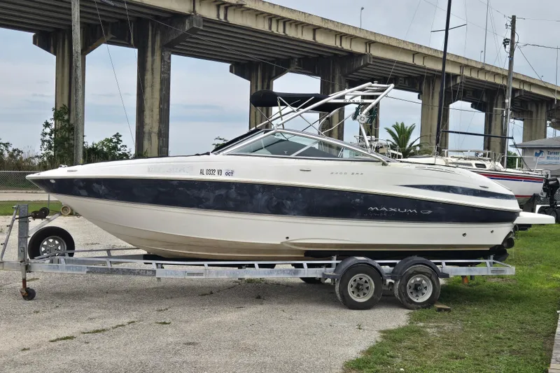 The Image of 2008 Maxum 2400 SR3 boat on trailer, parked near a bridge. - 0