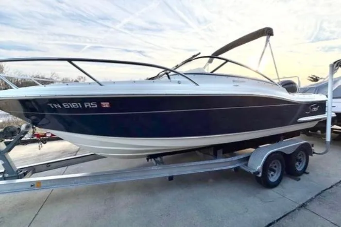 The Image of 2019 Scout 225 Dorado boat on trailer, sleek design, parked outdoors. - 0