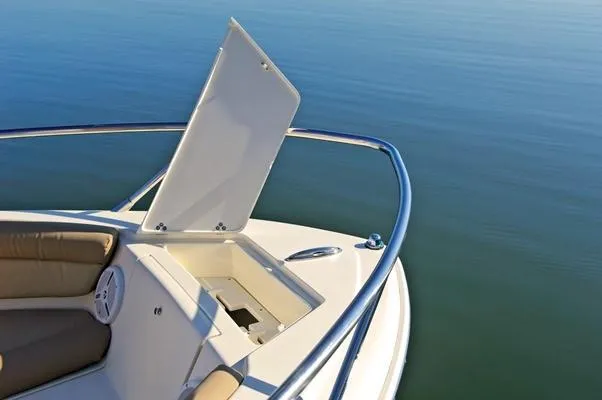 Slide: The Image of Manufacturer Provided Image: 2019 Scout 225 Dorado boat with open storage compartment on calm water. - 12