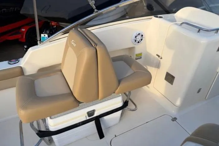 Slide: The Image of 2019 Scout 225 Dorado boat interior with tan seating and storage compartment. - 6