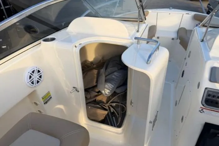 Slide: The Image of 2019 Scout 225 Dorado boat interior with open storage compartment and seating. - 7