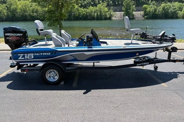 The Image of Blue 2018 Nitro Z18 boat with Mercury engine, parked near a scenic river. - 1