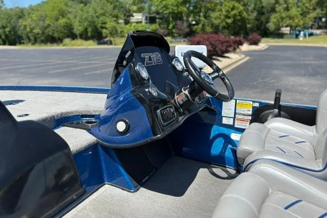 Slide: The Image of 2018 Nitro Z18 boat interior with steering wheel and dashboard in a parking lot. - 11