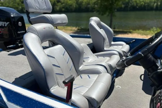 Slide: The Image of 2018 Nitro Z18 boat interior with sleek gray seats by a serene lake. - 27
