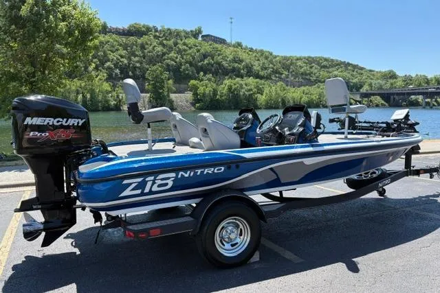 Slide: The Image of 2018 Nitro Z18 boat with Mercury Pro XS engine, parked by a scenic lake. - 3