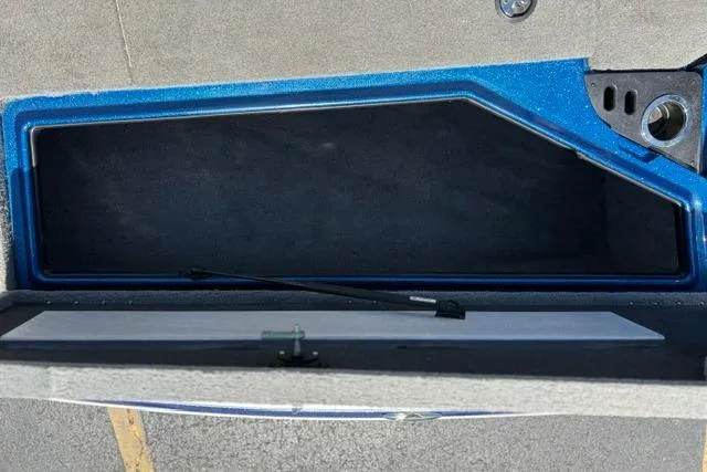 Slide: The Image of Open storage compartment in a 2018 Nitro Z18 boat, featuring a blue interior. - 57