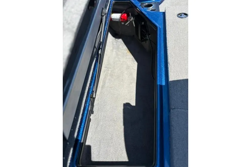 Slide: The Image of Open storage compartment in a 2018 Nitro Z18 boat, featuring blue trim and carpeted interior. - 58