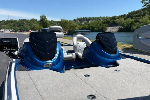 Slide: The Image of 2018 Nitro Z18 boat with dual seats, blue accents, and Lowrance equipment by a scenic lake. - 65