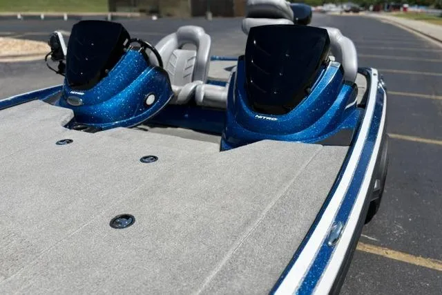 Slide: The Image of 2018 Nitro Z18 boat with blue accents and spacious deck in a parking lot. - 67