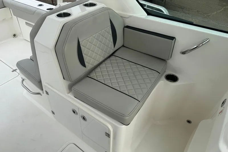 Slide: The Image of 2022 Pursuit DC 266 Dual Console boat interior with cushioned seating and cup holders. - 10