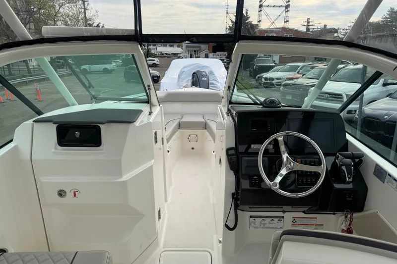 Slide: The Image of 2022 Pursuit DC 266 Dual Console boat interior with steering wheel and dashboard controls. - 11