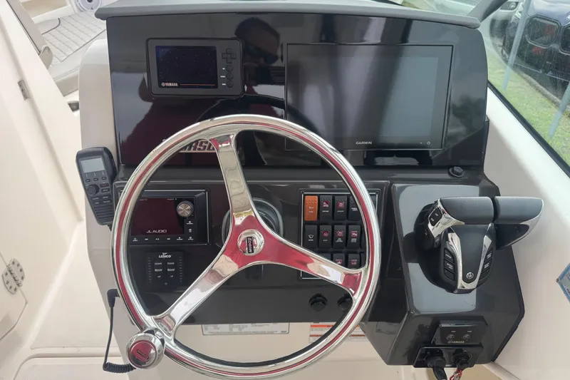Slide: The Image of 2022 Pursuit DC 266 Dual Console boat dashboard with steering wheel and control panel. - 14