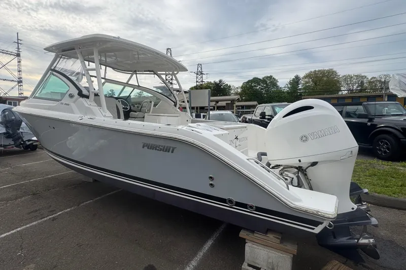 Slide: The Image of 2022 Pursuit DC 266 Dual Console boat with Yamaha engine, parked outdoors. - 2