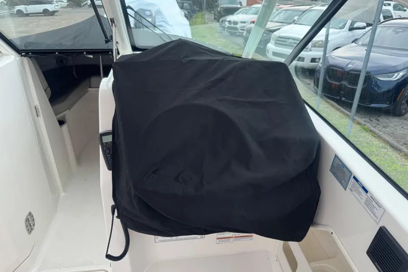 Slide: The Image of 2022 Pursuit DC 266 Dual Console interior with covered dashboard and visible seating area. - 21